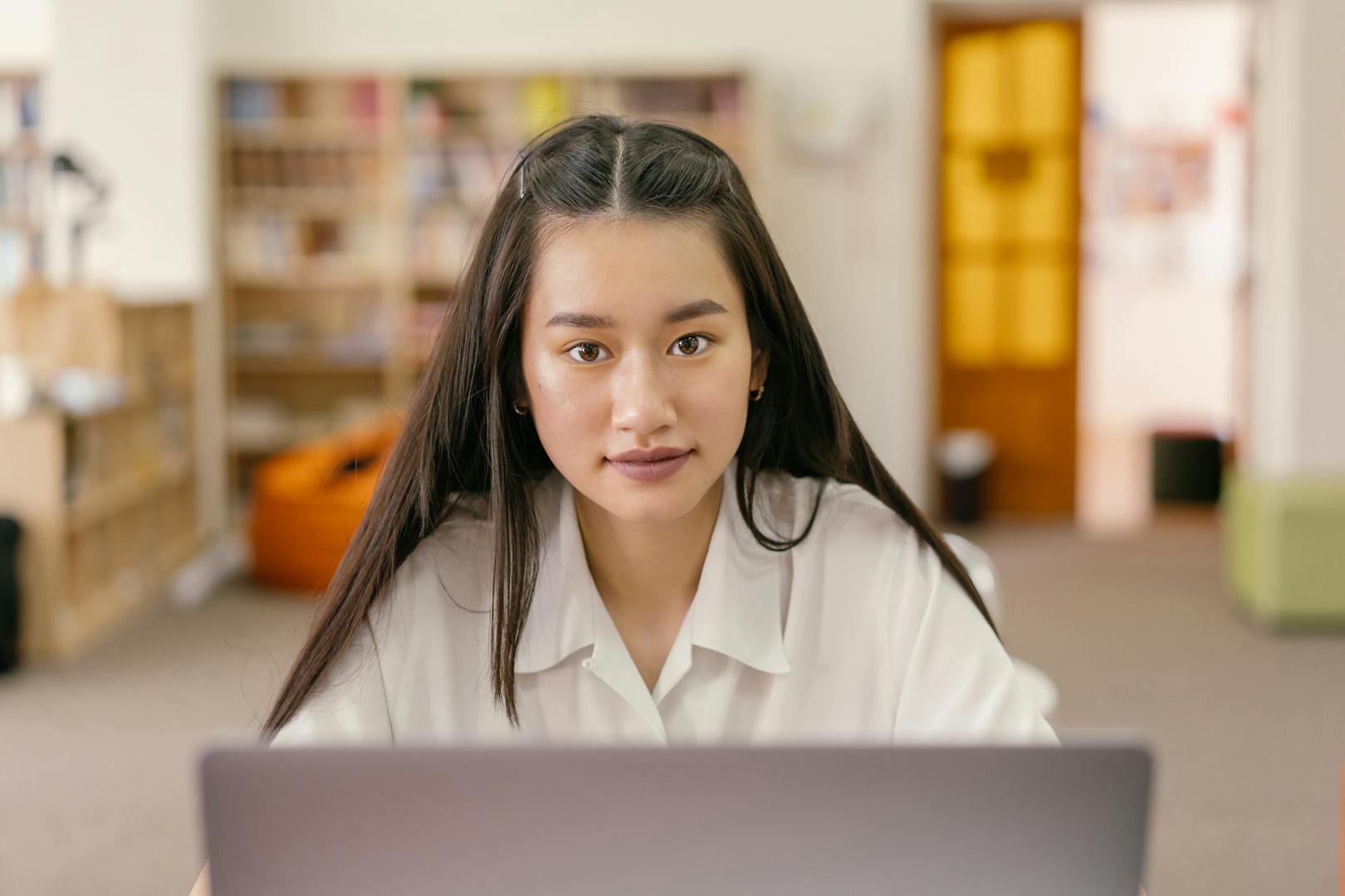 Learner studying online course materials in a library setting