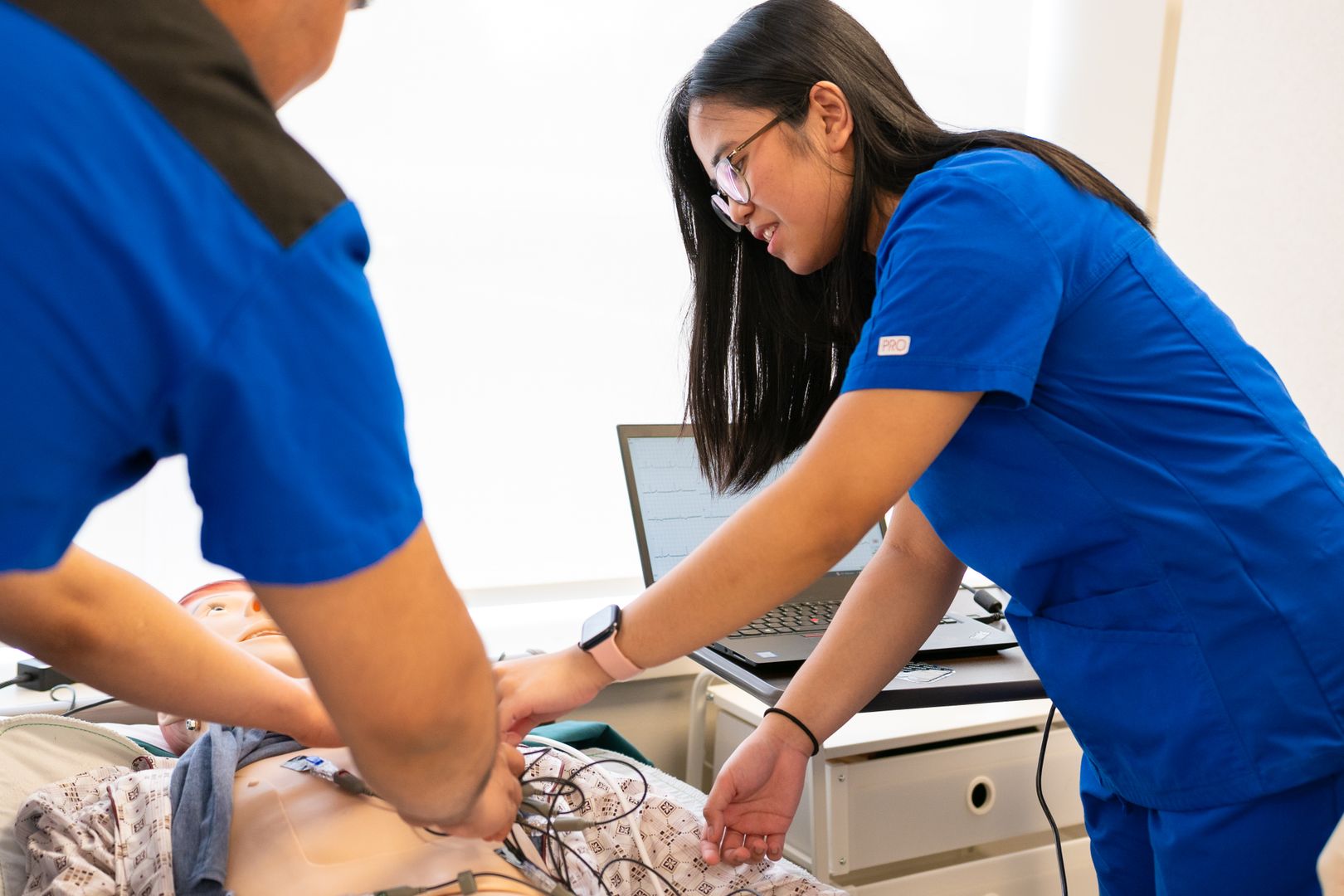 Instructor guiding a learner through a hands-on care procedure